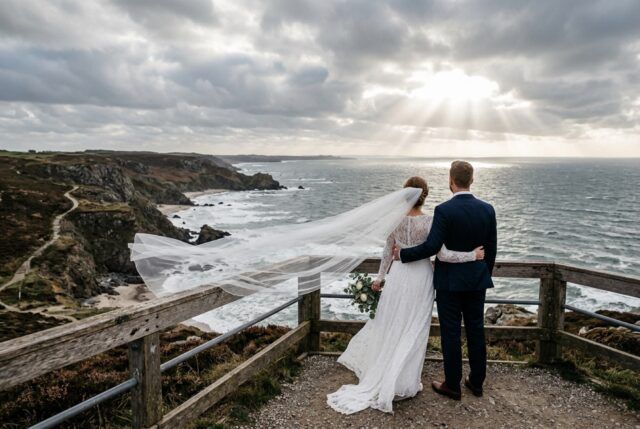 Heiraten in Bremerhaven: Brautpaar von hinten an der Küste, Schleier im Wind